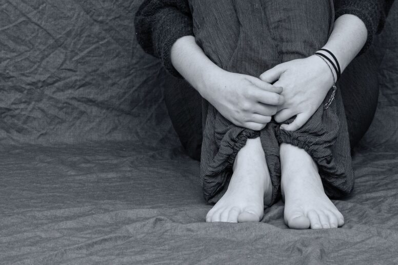 Imagem em preto e branco de pessoa triste para demonstrar a importância da Hipnose para depressão